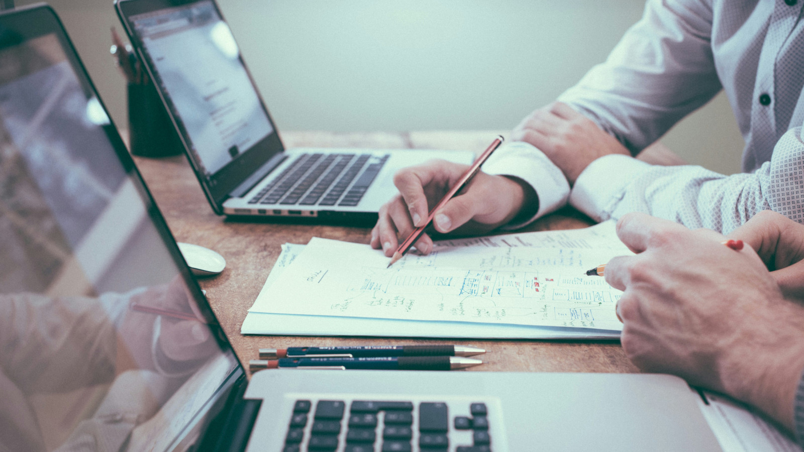 Zwei Herren konzepieren eine PIM Auswahl auf einem Zettel