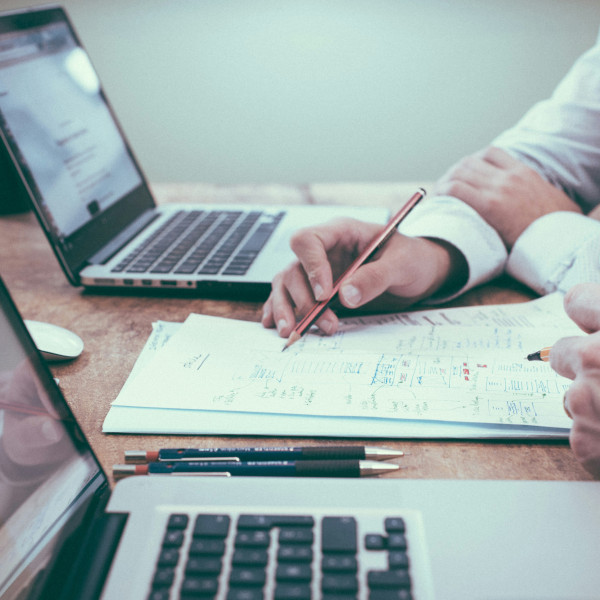 Zwei Herren konzepieren eine PIM Auswahl auf einem Zettel