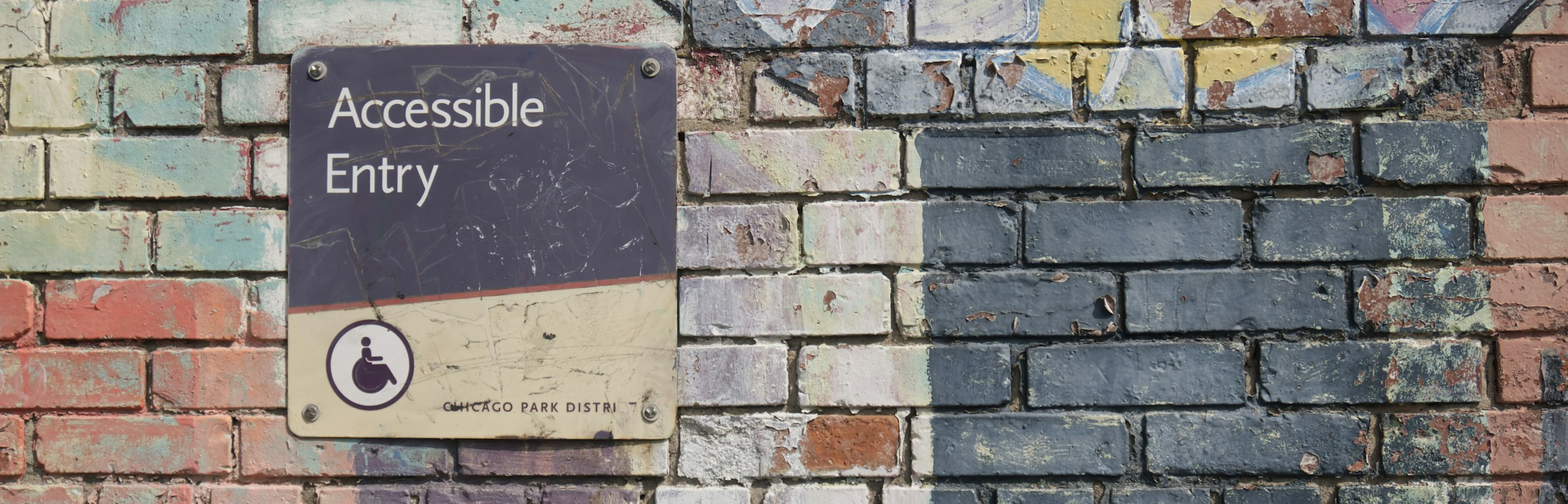 Schild Accessible Entry auf Wand, um die Relevanz der Barrierefreiheit zu zeigen