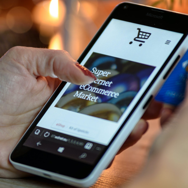 Eine Hand hält ein Smartphone mit einer geöffneten E-Commerce-Website