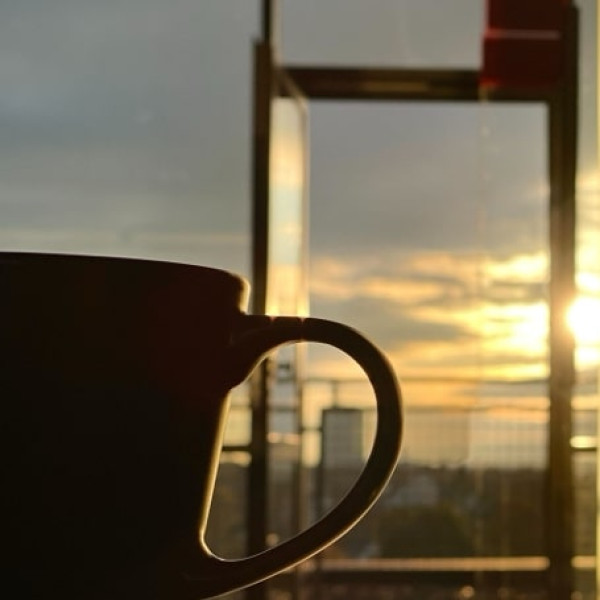 Hand bietet einen Kaffee in der Sonne an