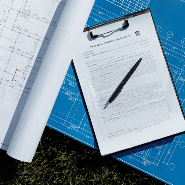 blaupausen-und-ein-stift-auf-dem-gras.